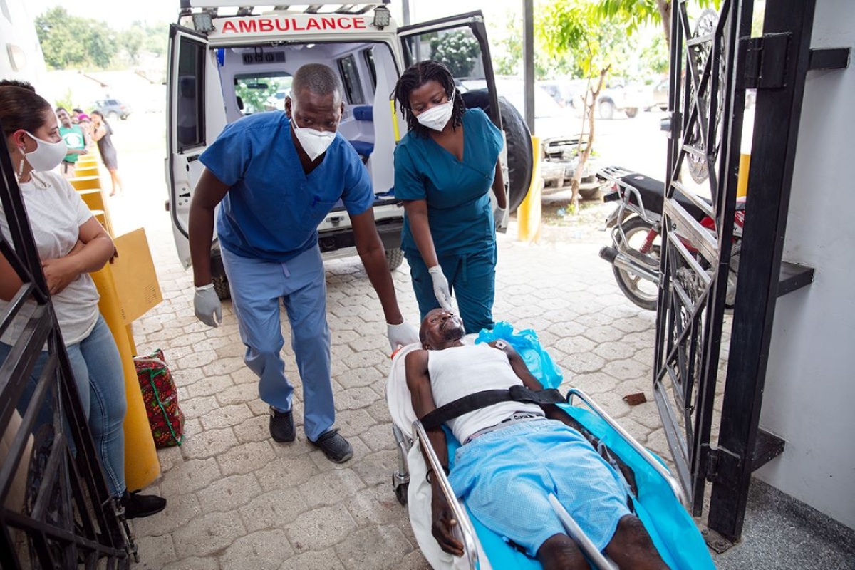 emergency clinicians carry earthquake survivor into ER in Haiti