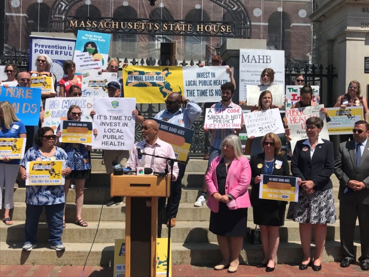 advocates gather outside the Boston Statehouse to support funding local health systems