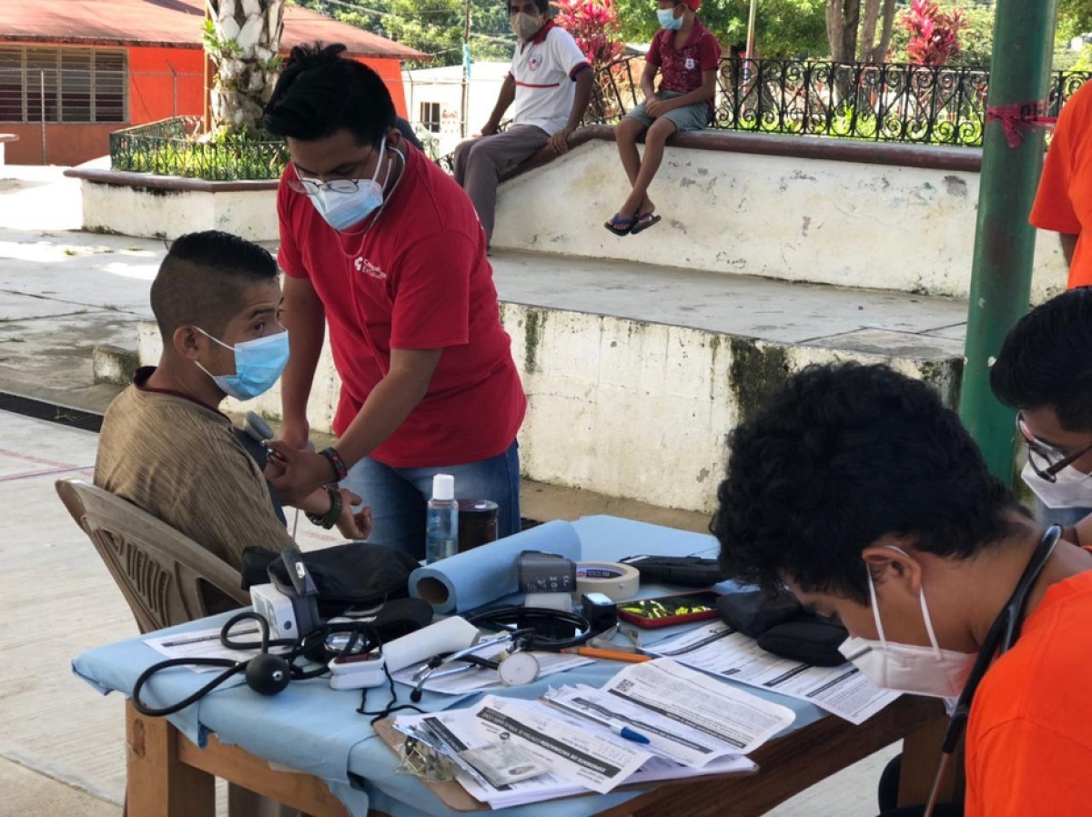 Tristán Luna, clinical assistant with Compañeros En Salud, takes vital signs of people at a vaccination site in Salvador Urbina, Chiapas.