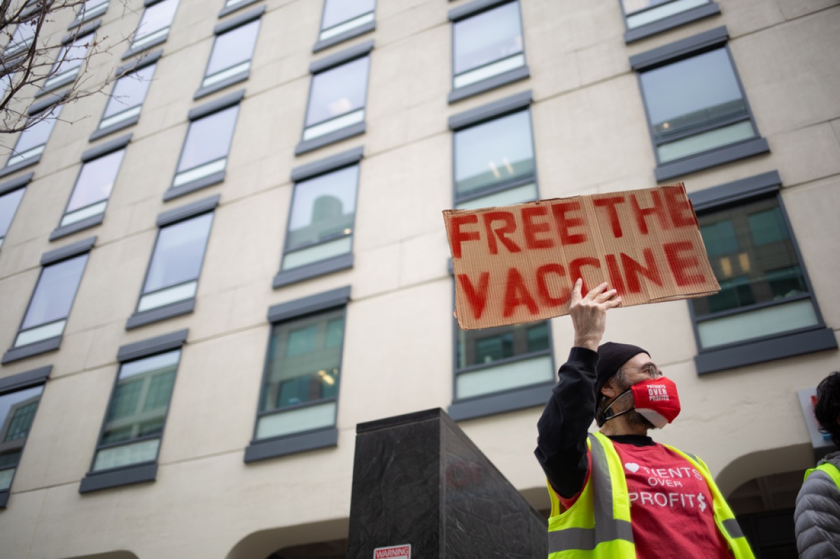 A protestor holds a sign that says "Free The Vaccine" in Cambridge, Massachusetts.
