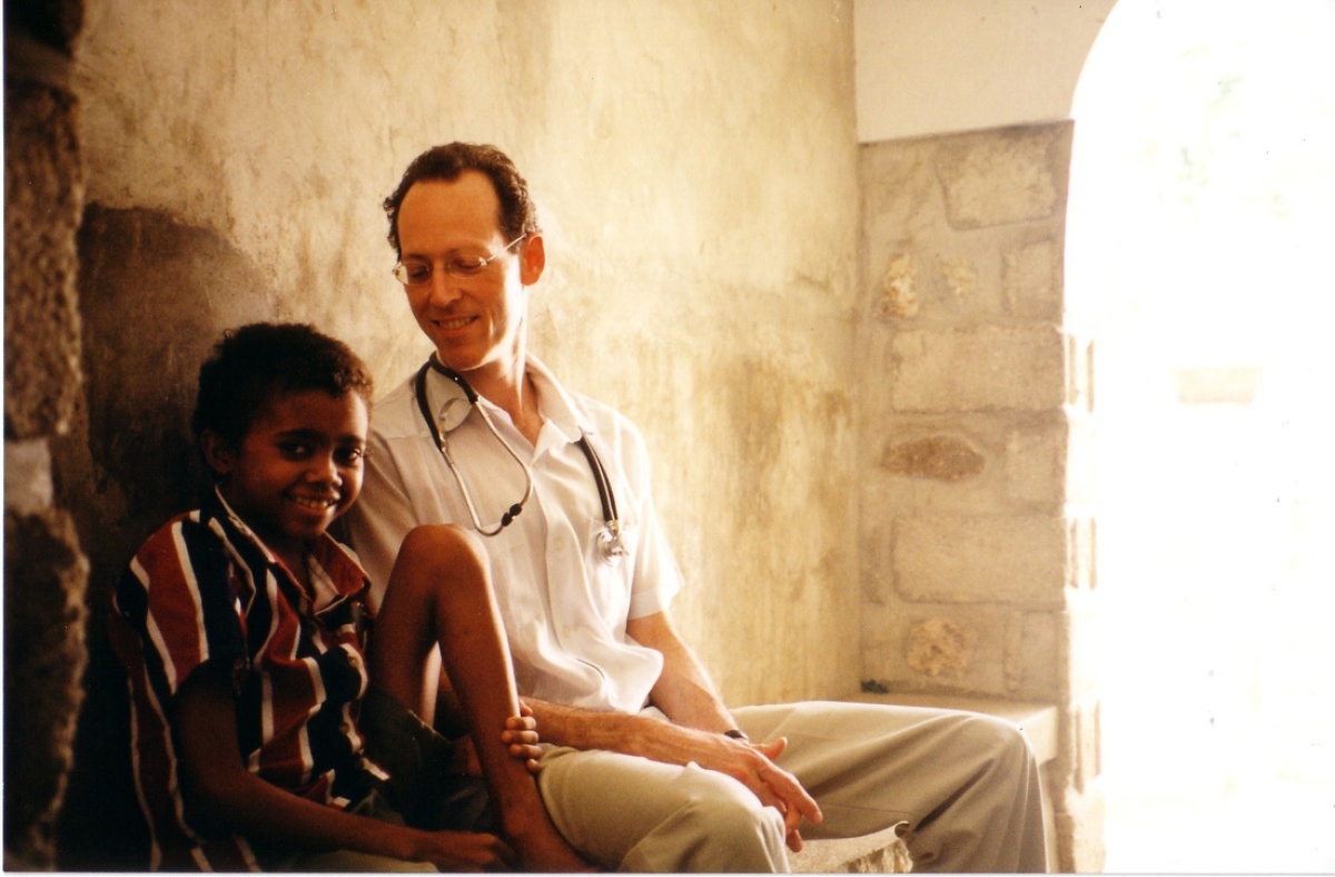 Dr. Paul Farmer sits with a young patient in Haiti.
