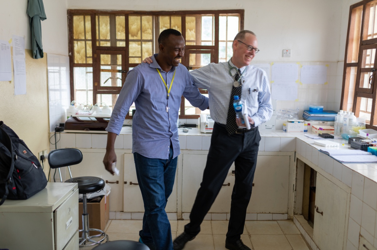 Paul Farmer walks with Musa Bangura, head of laboratory services for PIH-Sierra Leone, at Koidu Government Hospital.