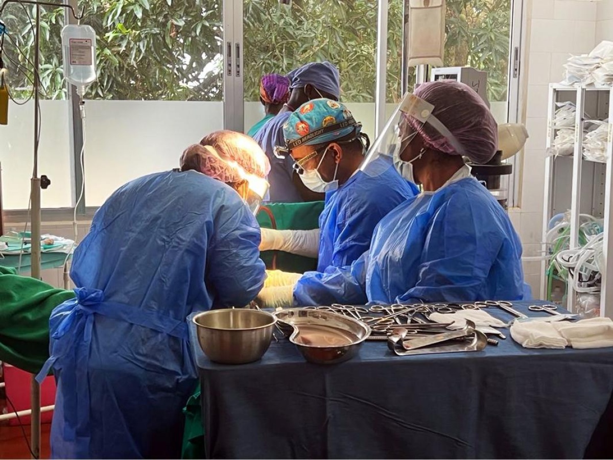 clinicians perform surgery on a patient 