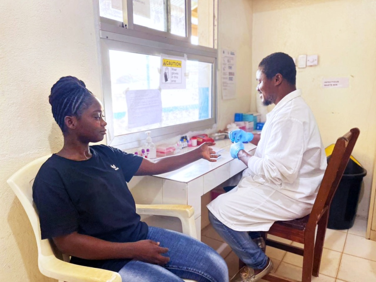 lab assistant tests patient for malaria 