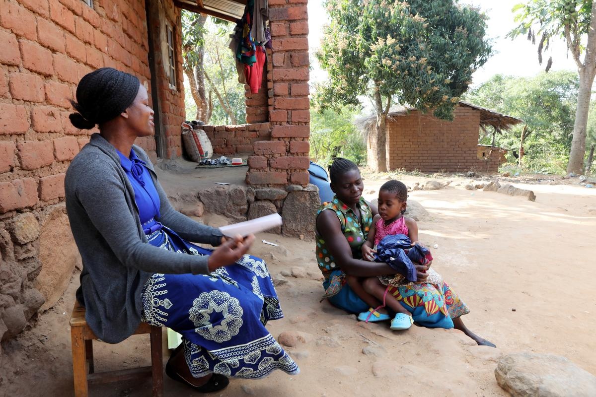 Community Health Worker Annie Jere visits with Milica Steven and her three children at their home in Neno, Malawi, screening the family for health concerns. Photo by Thomas Patterson / Partners In Health.