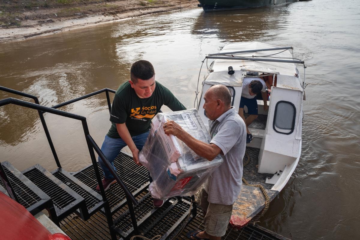 Health workers from Socios En Salud, as Partners In Health is known in Peru, unload equipment to provide free tuberculosis screenings in Loreto, a remote region in the Amazon rainforest.