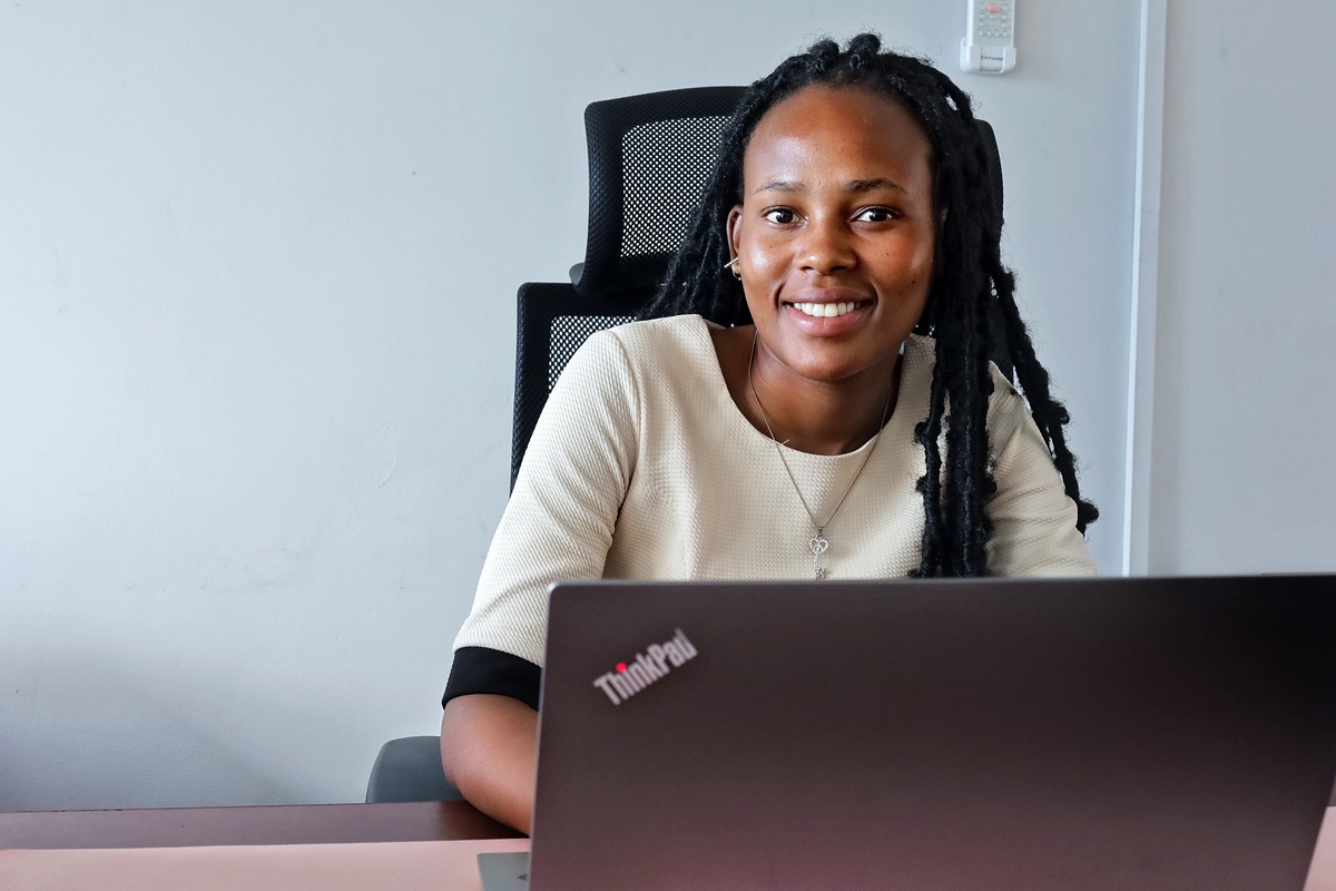 Mankopane Moeletsi smiling while sitting at a desk with laptop