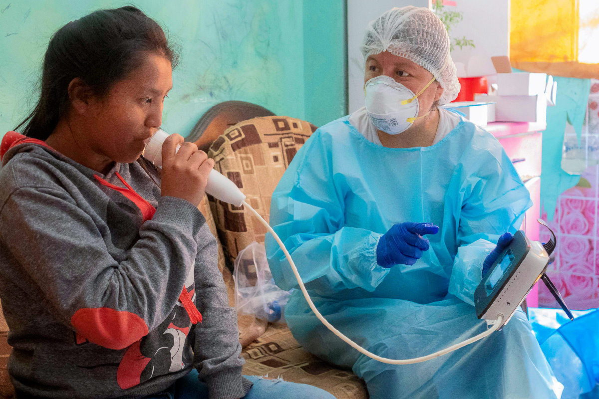Jajaira (left) performs lung function tests as a participant of Socios En Salud's study on post-tuberculosis teens