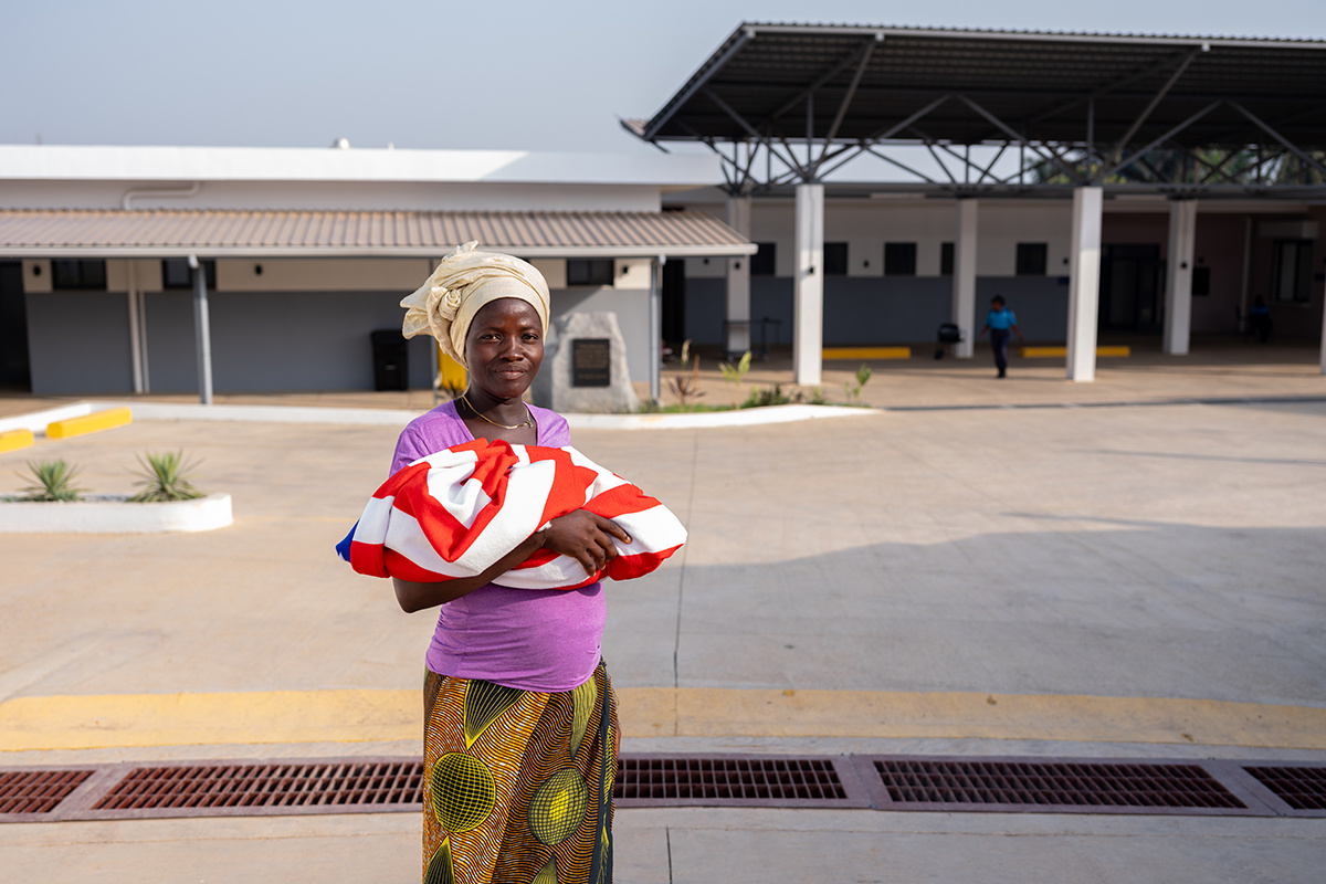Jeneba Koroma holds her newborn son outside the MCOE