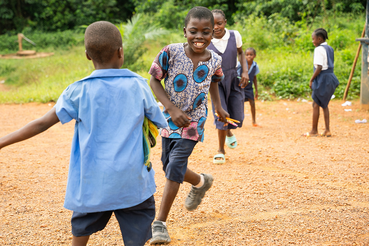 Dennis Toe smiles and runs alongside his classmates
