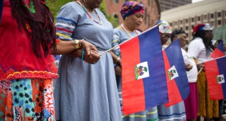 Women hold hands on Haitian Flag Day in Boston