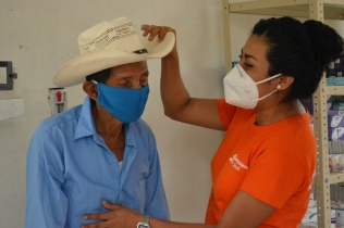 A patient receives care from a health worker with Compañeros En Salud.