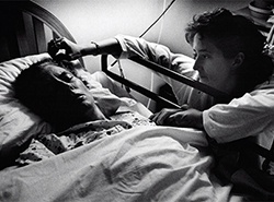 doctor with patient at beside holding their hand