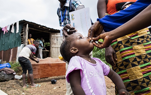 Fatu Kamara receives her first dose of oral cholera vaccine during a door-to-door campaign conducted by PIH.