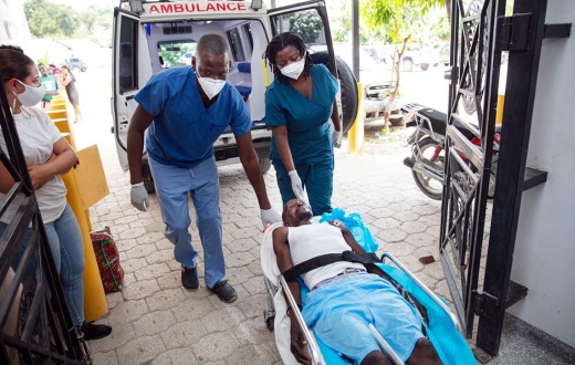 emergency clinicians carry earthquake survivor into ER in Haiti