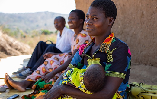 Agnes sits with her son, Ulemu, outside her home in Malawi.