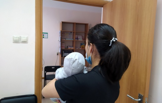 Samal, who declined to show her face for privacy reasons, holds her baby at the clinic where PIH works in Almaty, Kazakhstan.