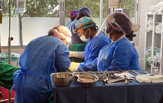 clinicians perform surgery on a patient 