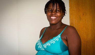 Patient standing outside her room at Kay Manmito, the maternal waiting home at University Hospital in Mirebalais
