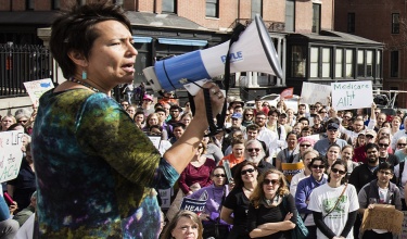 PIH Chief Medical Officer Dr. Joia Mukherjee speaks at a rally outside the Massachusetts State House speaking up in favor of access to health care for all.