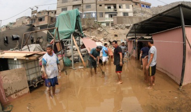 neighbors clear streets following massive floods in Lima, Peru