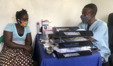 A patient sitting at a table receiving counseling from a midwife