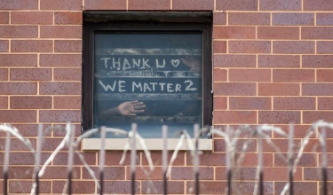 At Cook County Jail in Illinois, where COVID-19 has run rampant through prisons, incarcerated people hold a sign up to a window that says thank you, we matter too.
