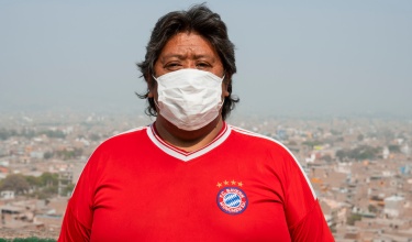Félix Melgar stands near his home in Carabayllo, Peru, with the city in the background.