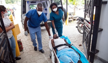emergency clinicians carry earthquake survivor into ER in Haiti