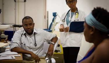 two clinicians meet with a patient with breast cancer