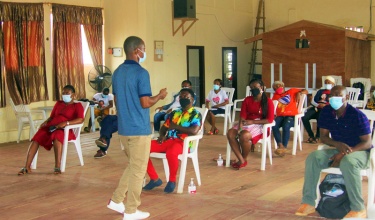 nurses sit indoors on white chairs during a training about delirium 