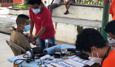 Tristán Luna, clinical assistant with Compañeros En Salud, takes vital signs of people at a vaccination site in Salvador Urbina, Chiapas.