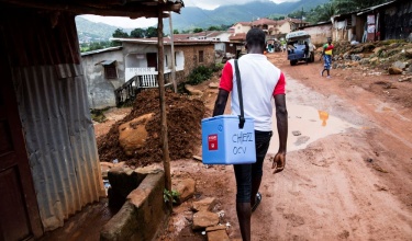government health worker carrying cooler with cholera vaccines