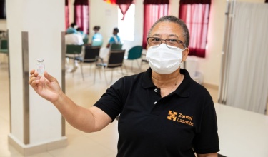 Loune Viaud holds a vaccine vial in Haiti