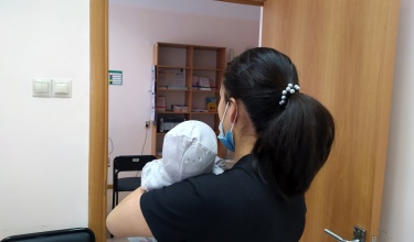 Samal, who declined to show her face for privacy reasons, holds her baby at the clinic where PIH works in Almaty, Kazakhstan.