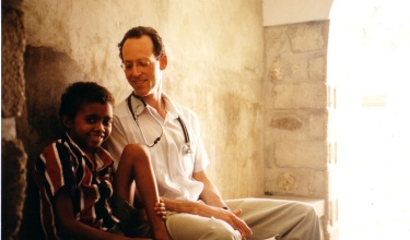 Dr. Paul Farmer sits with a young patient in Haiti.