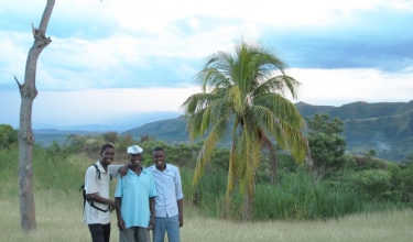 Haitian farmer St. Ker François stands with his family. He received HIV treatment for more than a decade from PIH community health workers.