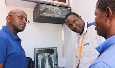 Dr. Melino Ndayizigiye speaks with staff