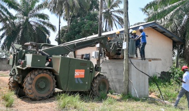 construction workers mount a transformer