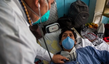 a clinician examines a tuberculosis patient in Peru