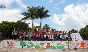 Teens and youth stand by a mural painted at the end of a three-day workshop on reproductive rights hosted by Compañeros En Salud, as Partners In Health is known in Mexico.