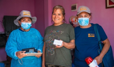 Meysi Mendoza (center) stands with Elizabeth Anchante (left) and Guadalupe (right), community health workers with Socios En Salud, as Partners In Health is known in Peru.