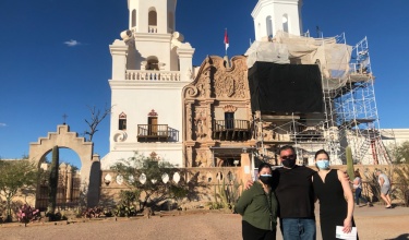 Manny Montano (center) stands in front of San Xavier del Bac Mission
