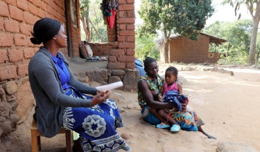Community Health Worker Annie Jere visits with Milica Steven and her three children at their home in Neno, Malawi, screening the family for health concerns. Photo by Thomas Patterson / Partners In Health.