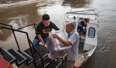 Health workers from Socios En Salud, as Partners In Health is known in Peru, unload equipment to provide free tuberculosis screenings in Loreto, a remote region in the Amazon rainforest.