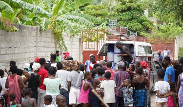 Humanitarian aid workers distributing supplies from a van.