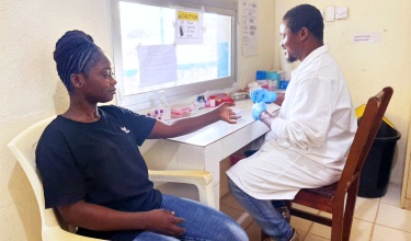 lab assistant tests patient for malaria 