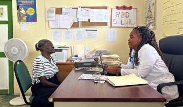 Acefie Théodore (left) sits across a brown desk from Dr. Stéphanie Laphague (right).