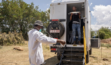 PIH's Nkosana September (right) and Ts'epo Ts'umane (left), a lab technician, by the mobile X-ray truck