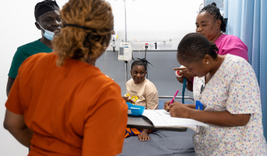 Staff and patient Fatmata Jalloh in the triage area at the MCOE